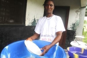 Patricia Miller, a domestic worker in liberia washes dishes at the back of her bosses home in the Stephen Tolbert Estate in Liberia. she loves the job she do because it is her only means of income. without this job Ms. Miller would have been a sole lability on her family.