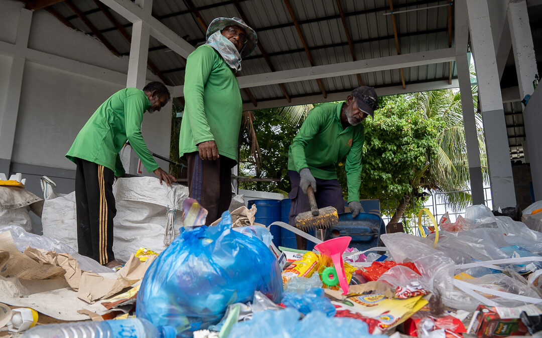 Workers at a Maldives recycling plant pick through garbage to find recyclable plastics